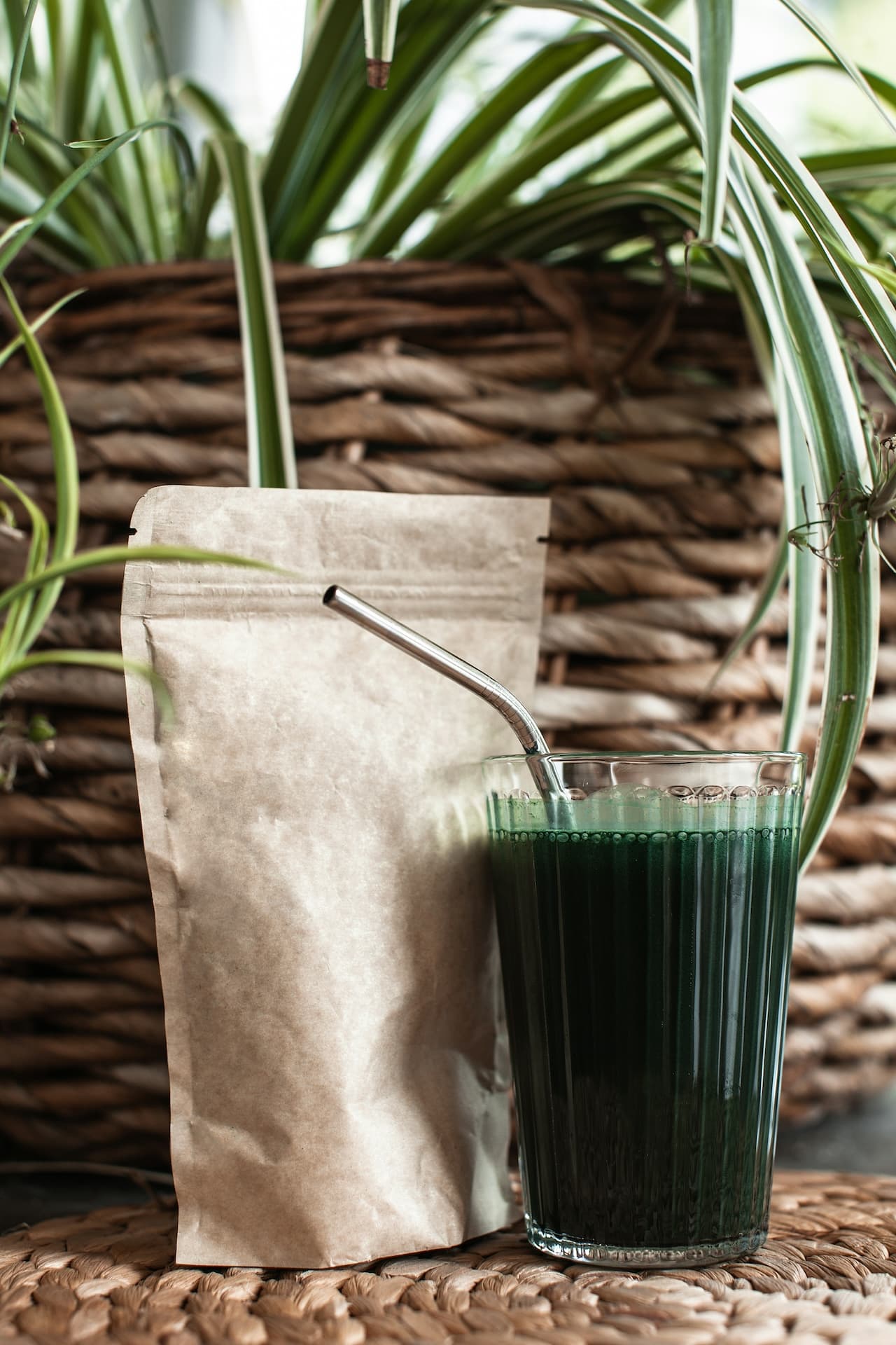 Spirulina supplement powder in brown paper bag and spirulina supplement drink in glass with straw.
Photo by Supliful - Supplements On Demand on Unsplash.